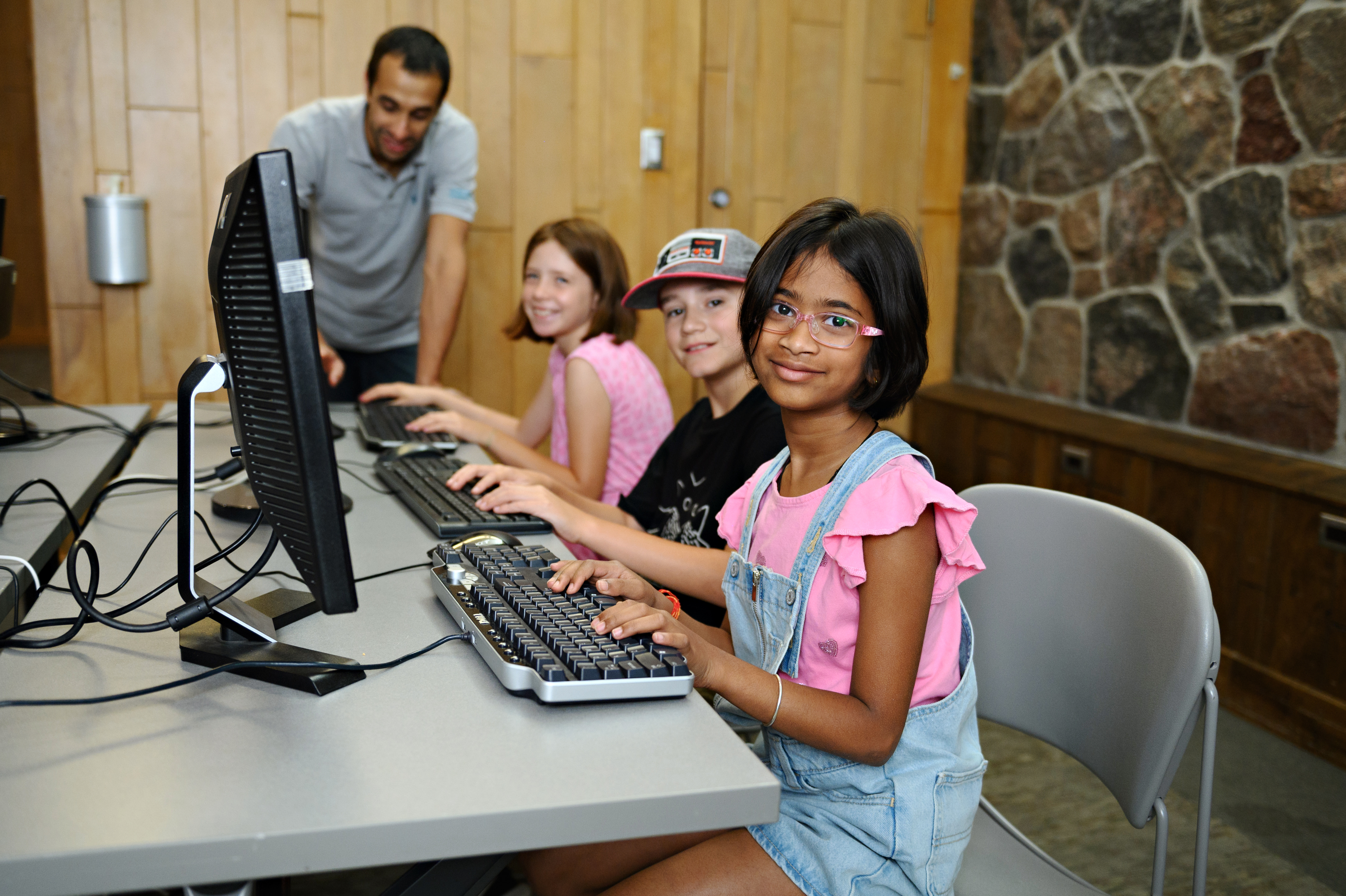 Students working in a computer lab with the teacher