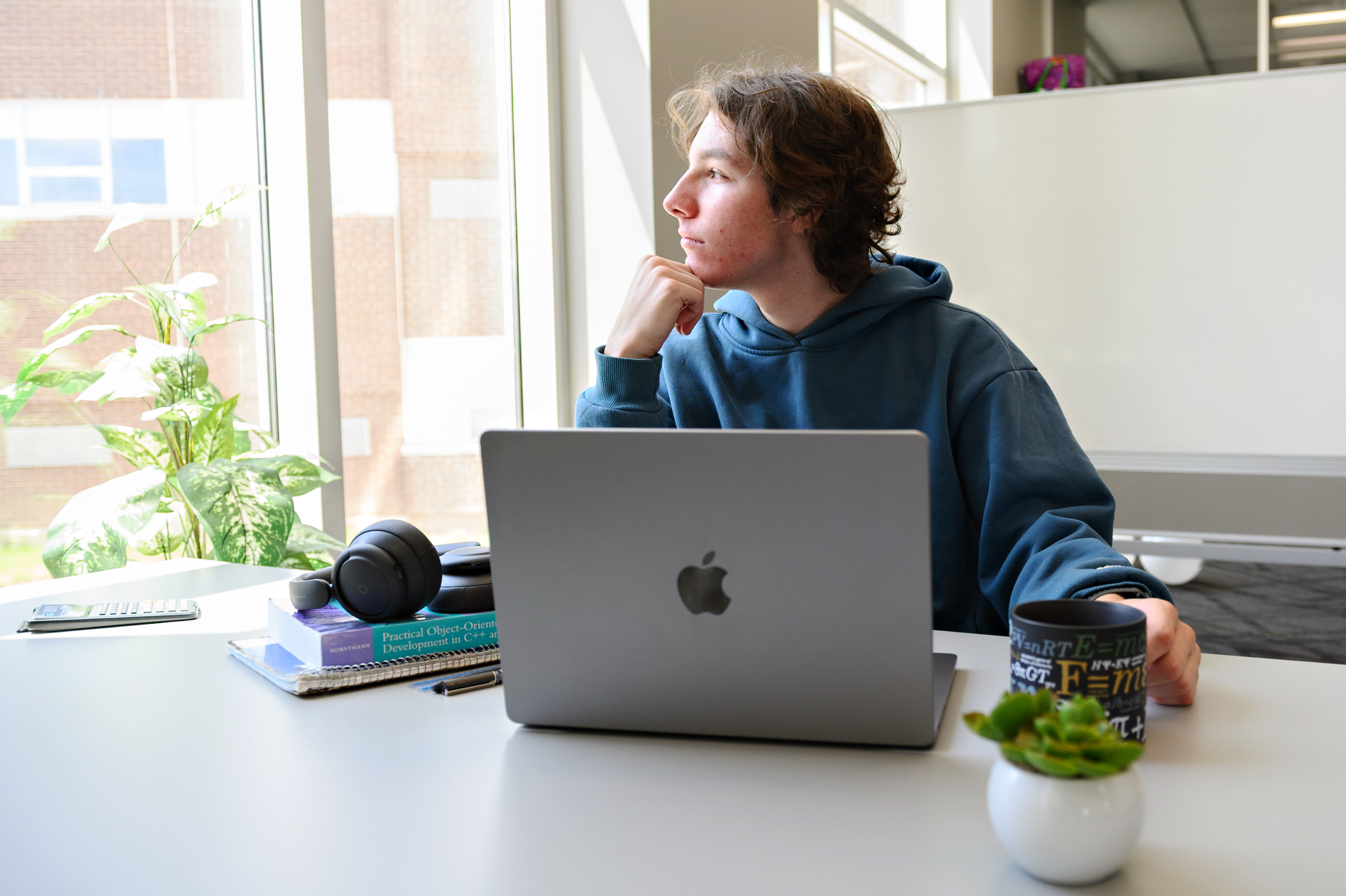 Student working on the laptop looking outside the window