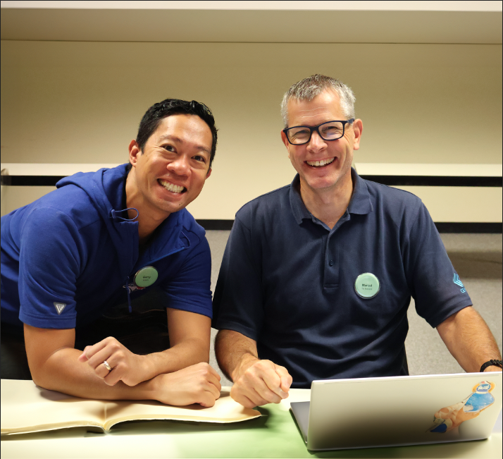 Educators working together at a CEMC event and smiling into the camera