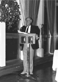 Ron Dunkley standing in front of a podium presenting