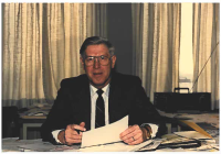 Ron Dunkley sitting at his desk with papers