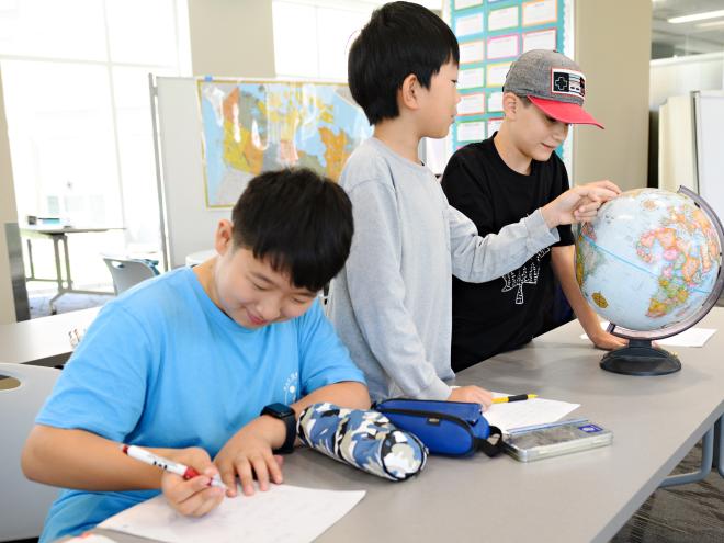 Group of students playing with a globe