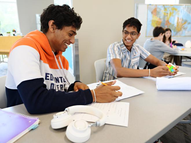 Students solving math and smiling at each other